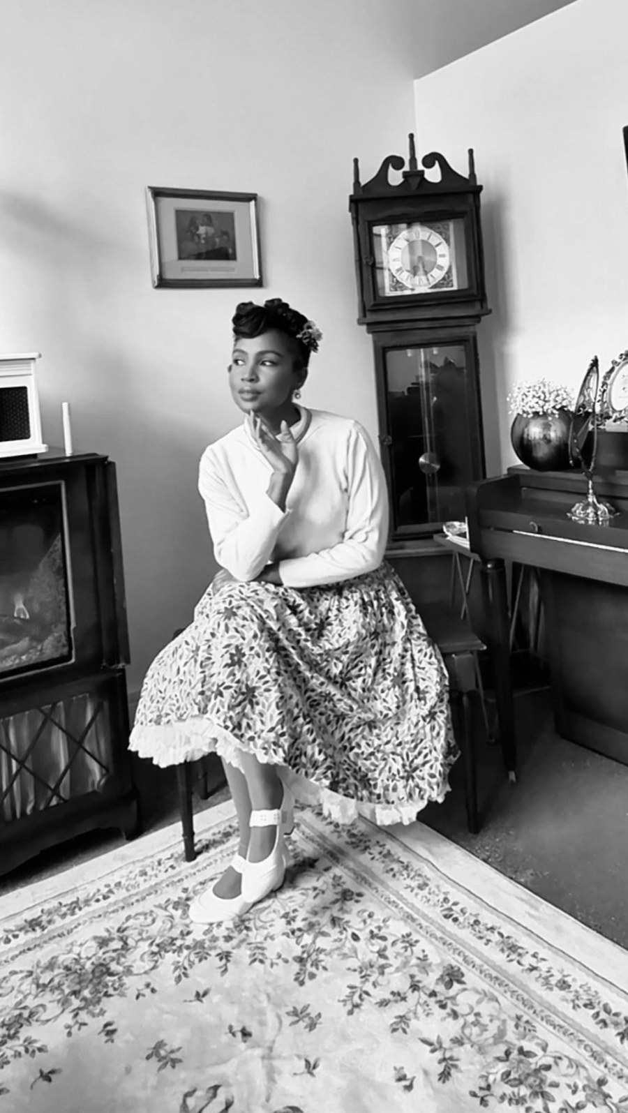 Cazlinn Carstens seated in her vintage-styled studio, in black and white