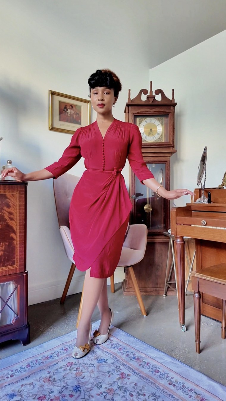 Red dress, front-facing, in a vintage-styled room